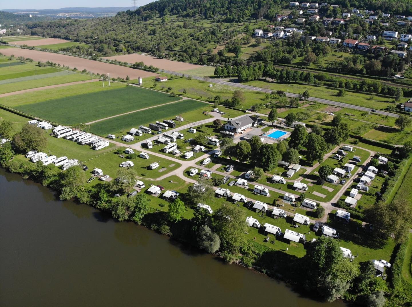 Luftaufnahme des Campingplatzes Cimbria am Neckar bei Neckarzimmern: Stellplätze, Schwimmbad und der Fluss im Vordergrund